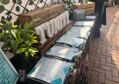 Group gathered under event canopy with Tuniti banner and gift bags.