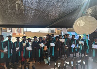 Graduates lined up for group photo with certificates and smiles.