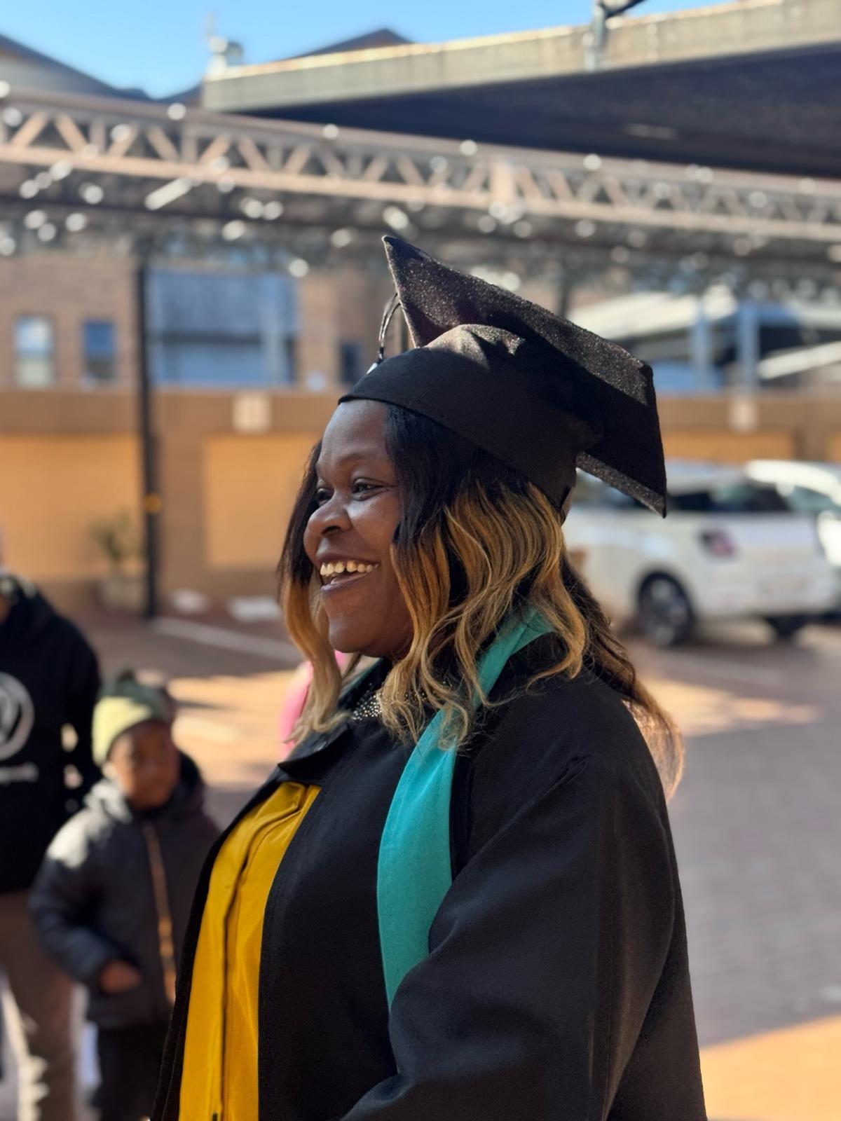 image7 Joyful Tuniti Care Hero graduate in cap and gown smiles proudly at 2025 caregiver graduation, celebrating achievement in caregiver training.